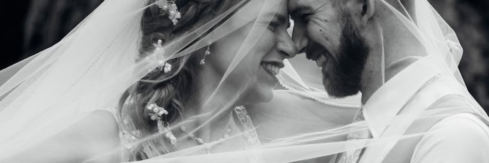 Bruidspaar onder bruidssluier in zwart wit