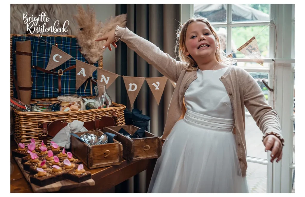 Bruidsmeisje wijst enthousiast naar candytable met zoetigheden tijdens bruiloft bij Slotplaats Bakkeveen