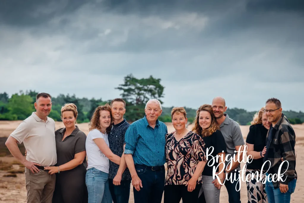Groepsportret van volwassen kinderen met hun ouders tijdens een familieshoot in de duinen
