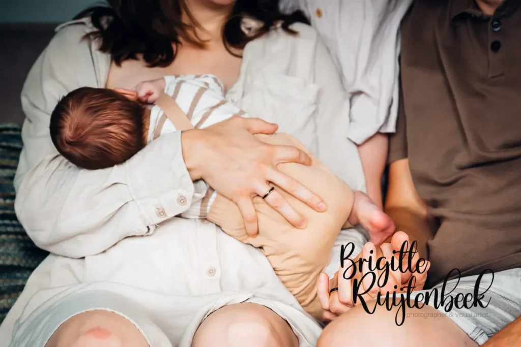 Detailfoto van een moeder die haar baby voedt tijdens een newbornshoot aan huis.
