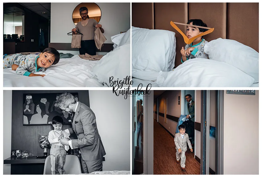 Vader helpt zijn jonge zoon in pak tijdens de ochtendvoorbereiding in een hotelkamer op de trouwdag.
