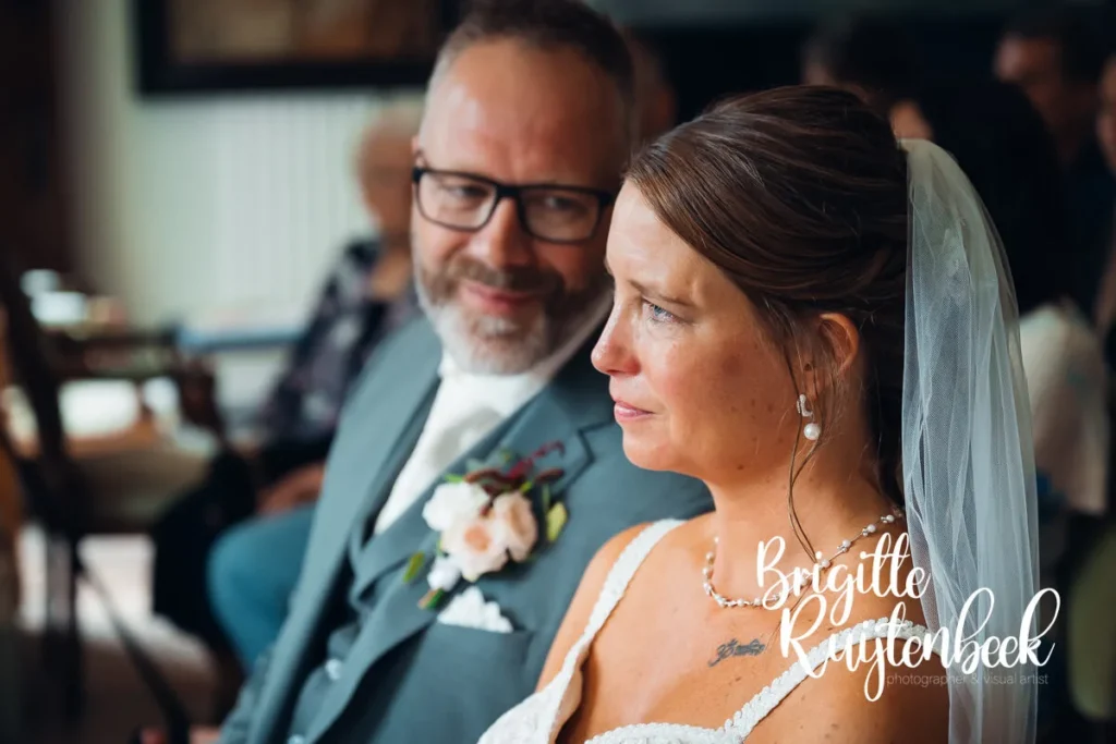 Close-up van een bruid die ontroerd luistert tijdens de trouwceremonie bij de Fraeylemaborg, terwijl de bruidegom haar liefdevol aankijkt.