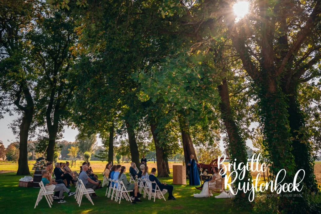 Bruiloft van Sandra en David met een buiten ceremonie onder de bomen bij Trouwboerderij Mausel in Noordbroek.