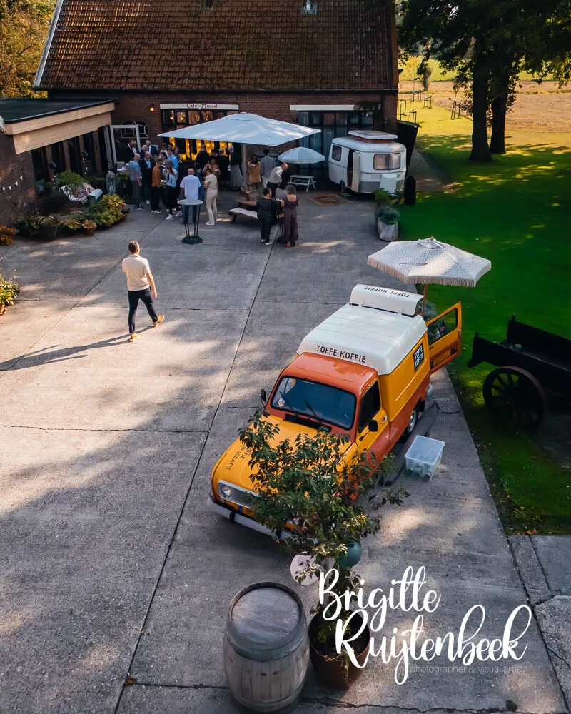 Dronefoto van Toffe Koffie oldtimer met barista op binnenplaats van Trouwerij Boerderij Mausel in Noordbroek