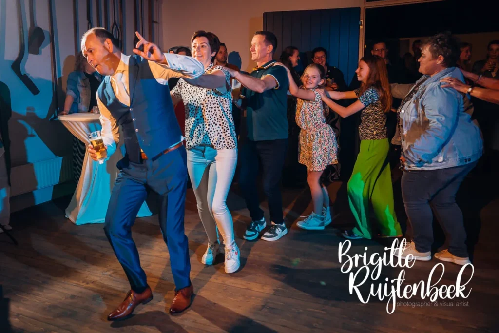 Gasten in polonaise tijdens de feestavond van een bruiloft in Noordbroek.