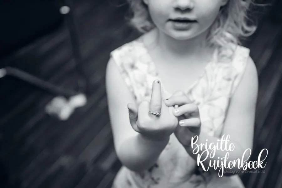 Kind maakt een uitgesproken gebaar tijdens een onbewaakt moment op de bruiloft