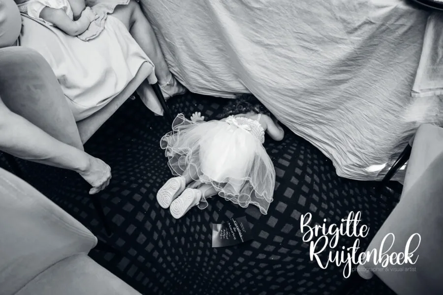 Kind ligt onder tafel verstopt tijdens de bruiloft terwijl de ceremonie doorgaat