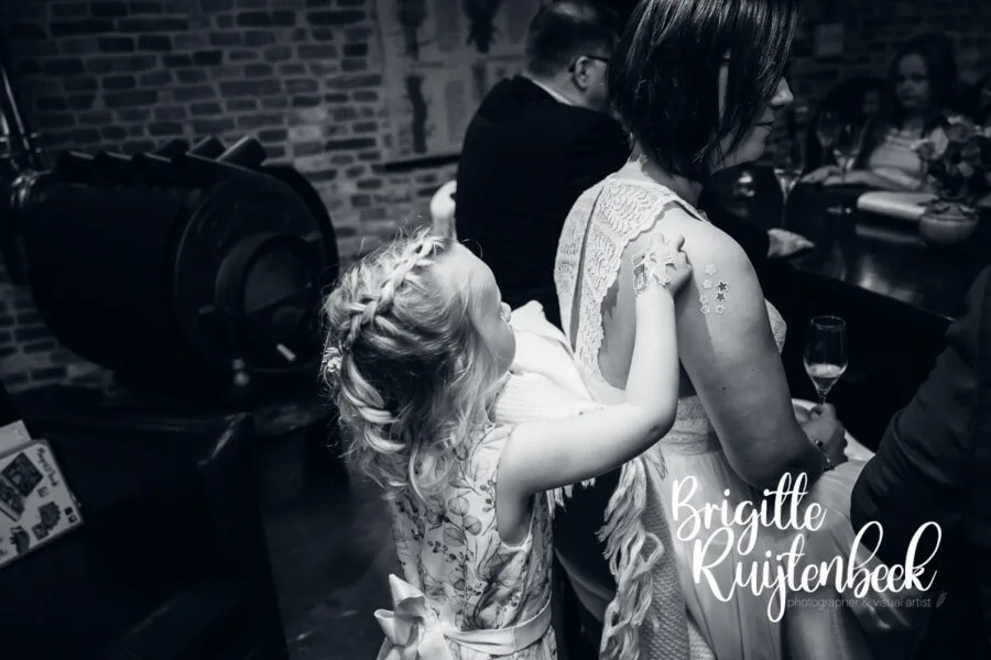 Kind plakt stickers op de rug van een volwassene tijdens het feest