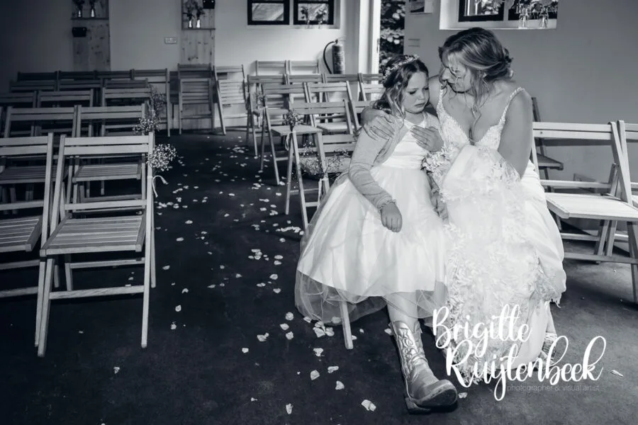 Bruid zit naast een kind dat steun zoekt na afloop van de ceremonie