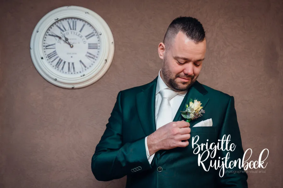 Bruidegom Stephan trekt zijn trouwpak aan tijdens de voorbereidingen van een winterbruiloft op kerstavond in Drenthe