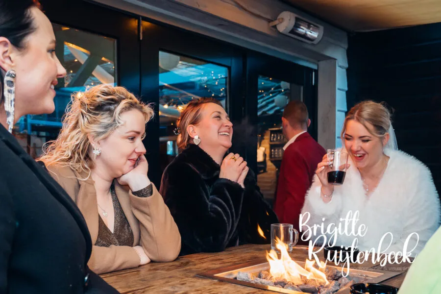 Gasten warmen zich bij het vuur tijdens de avond van een winterbruiloft bij De Kruimel in Gasselte