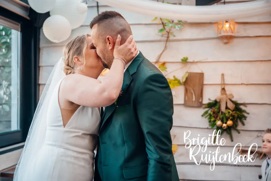 Bruidspaar kust elkaar na het jawoord tijdens de ceremonie bij De Kruimel in Gasselte