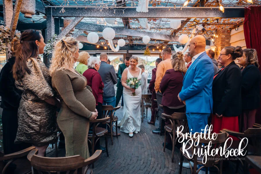 Bruidspaar loopt samen door de gasten na afloop van de ceremonie bij De Kruimel in Gasselte