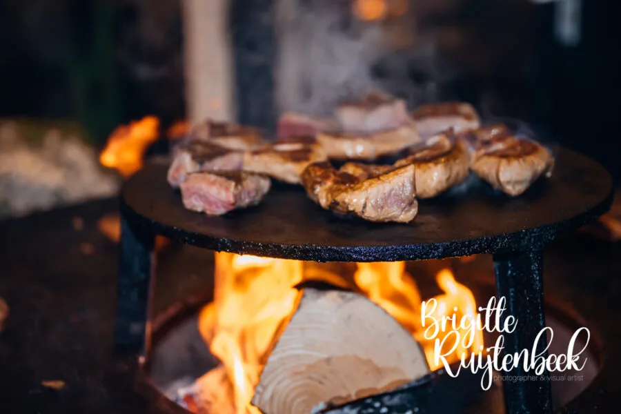 Vlees wordt bereid op open vuur tijdens de avond van een winterbruiloft in Gasselte, Drenthe